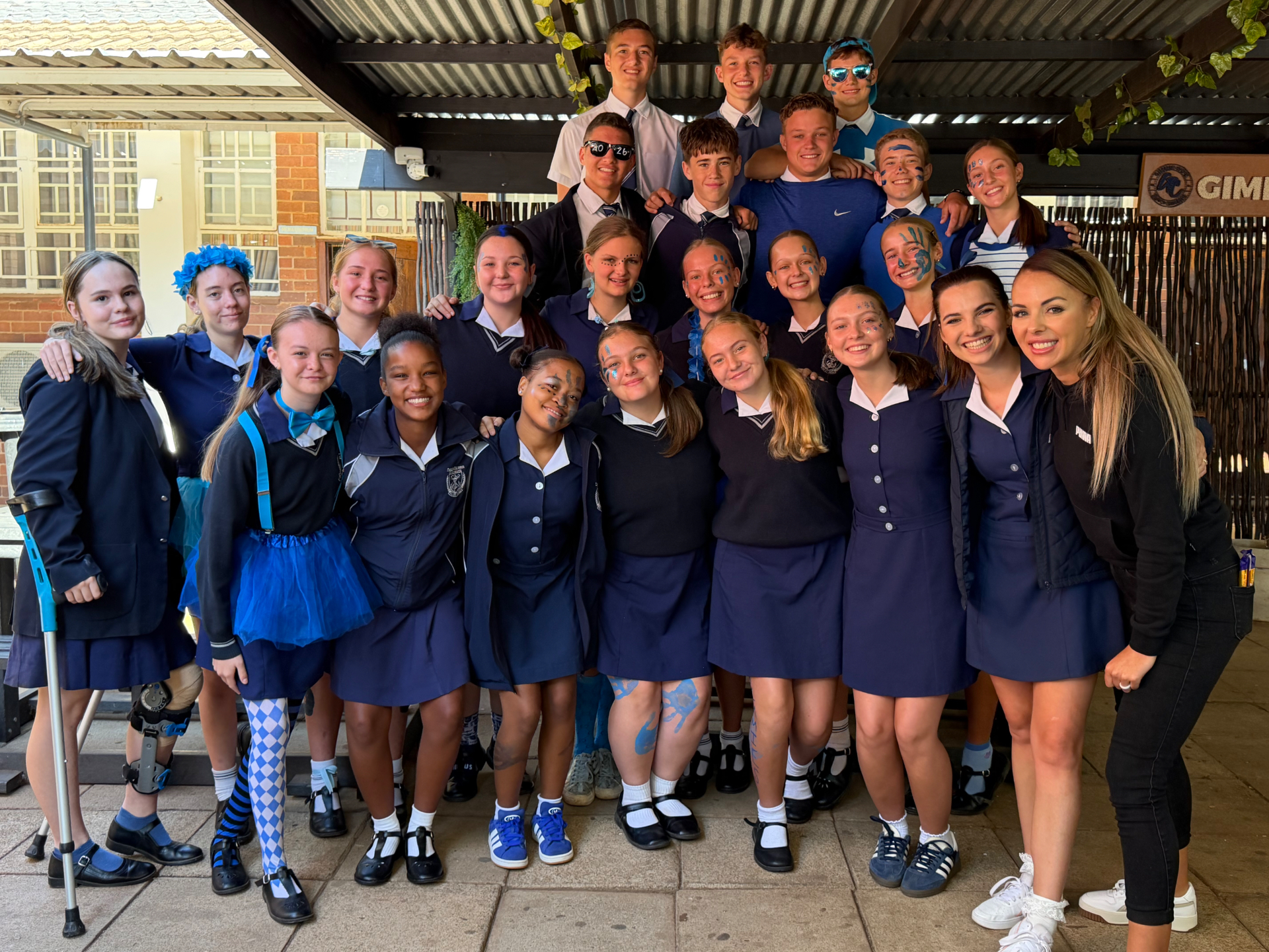 Nastassja Ras with a large group of learners in blue spirit-day dress at a school visit