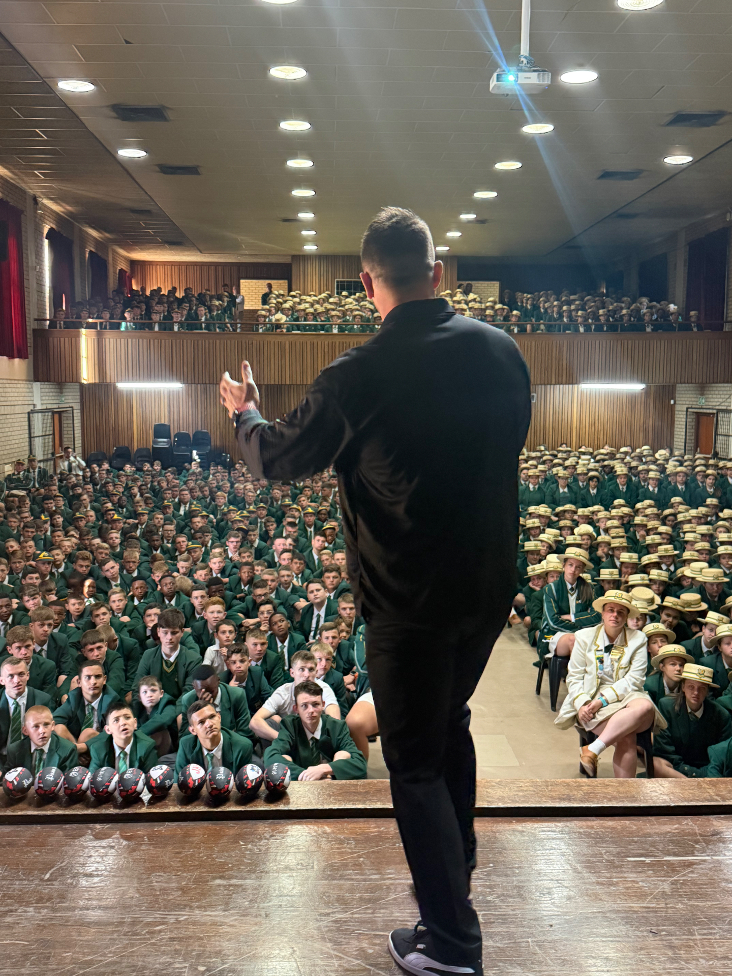 Jaco Kriel addressing a packed school hall from the stage