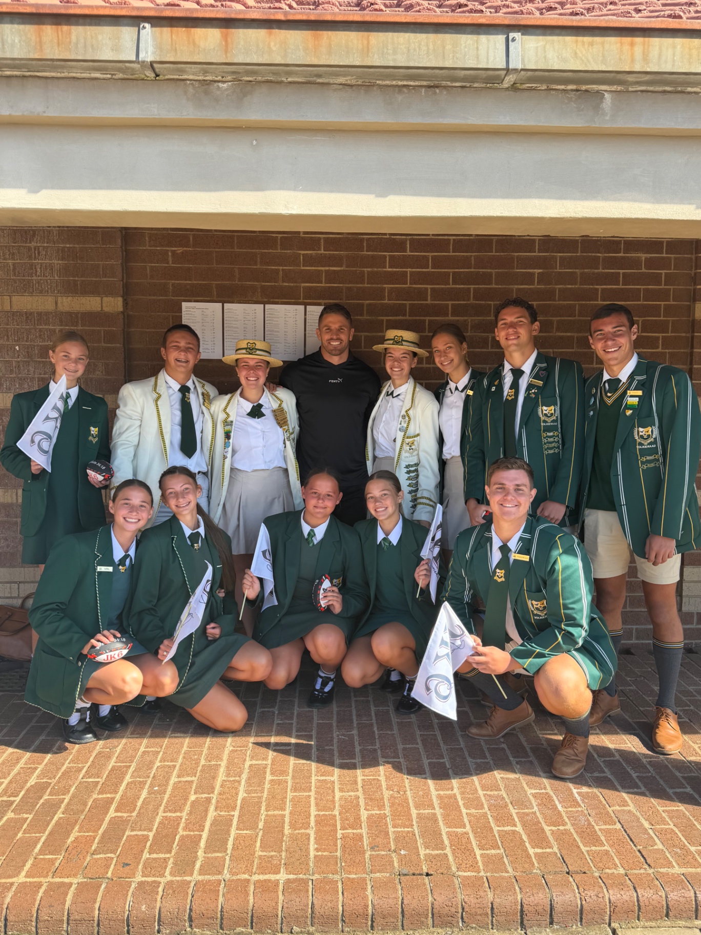 Jaco Kriel with high school prefects holding JK6 flags and signed rugby balls