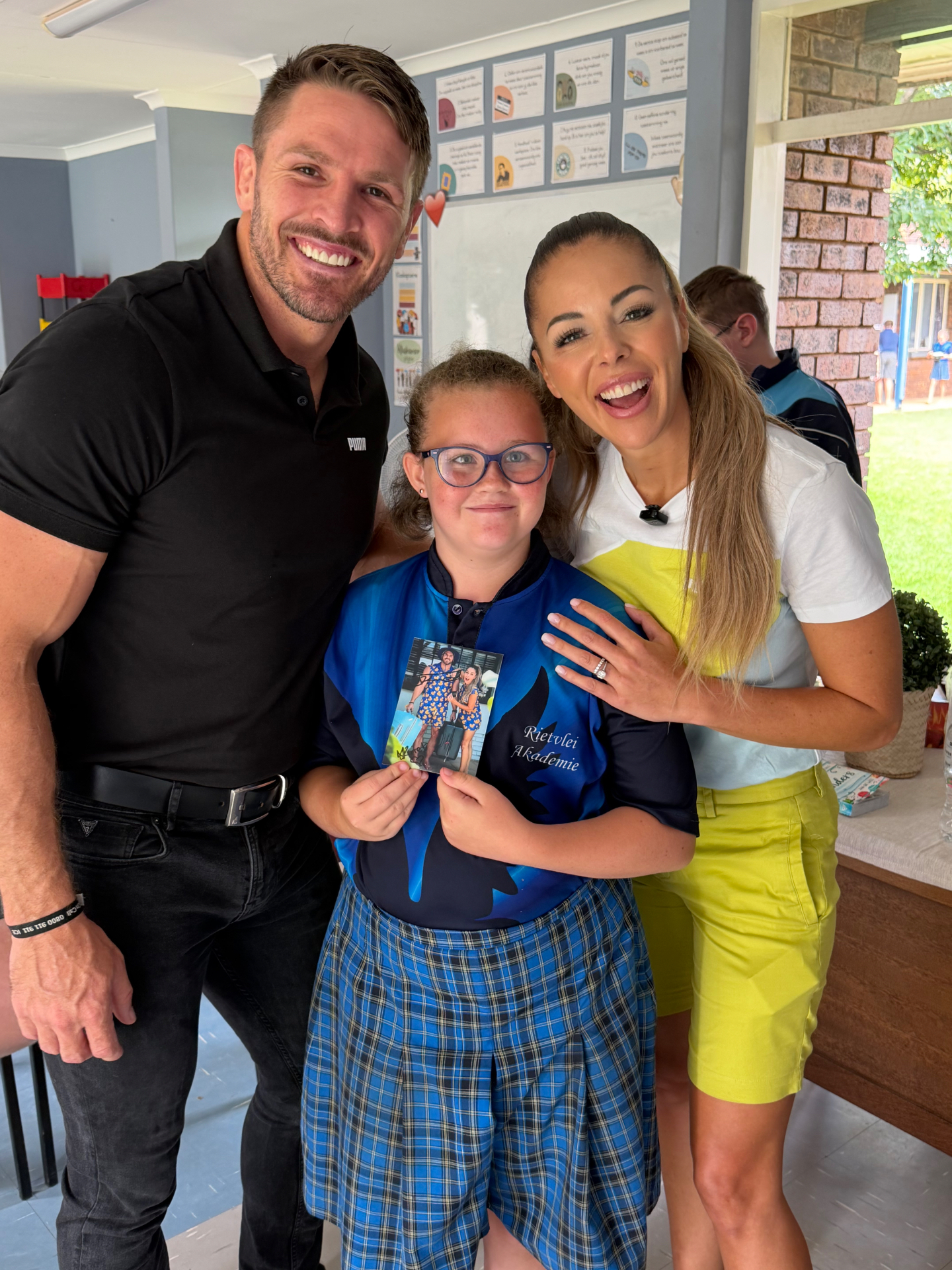 Jaco Kriel and Nastassja Ras with a Rietvlei Akademie learner holding a signed photo