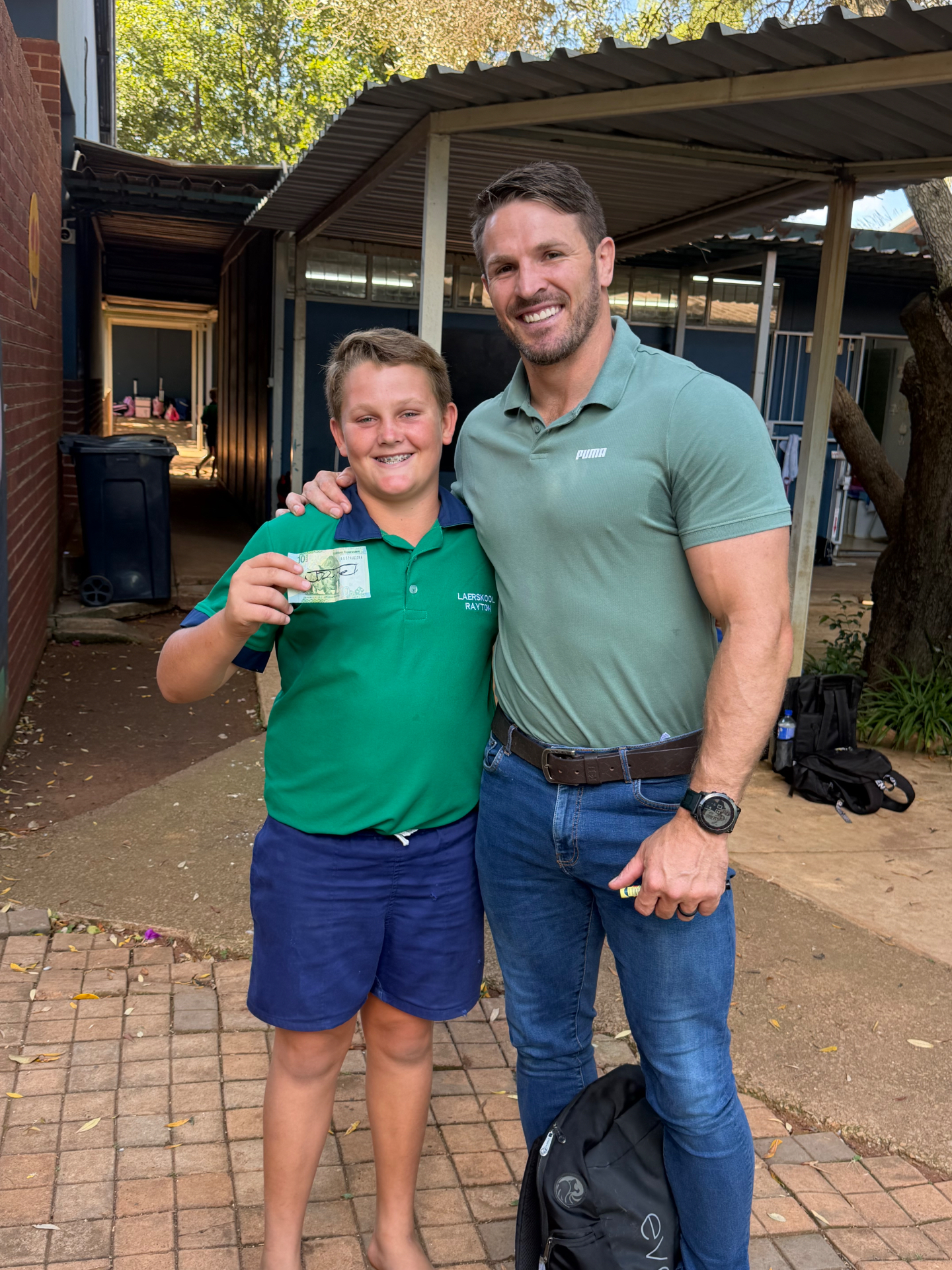 Jaco Kriel with a Laerskool Rayton learner holding a signed banknote