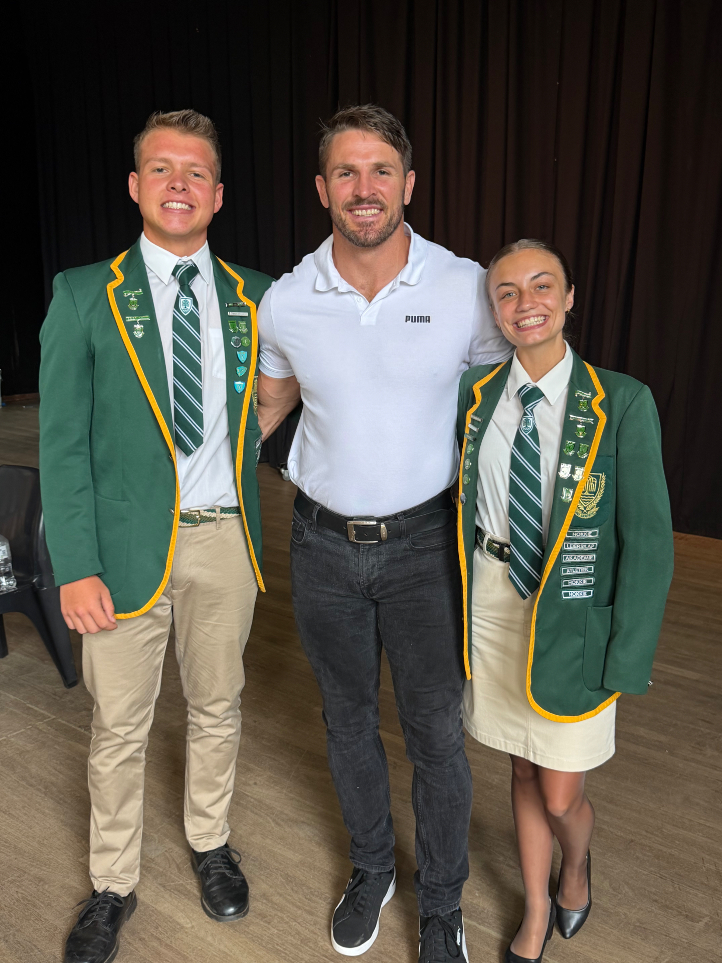 Jaco Kriel with two high school prefects in green blazers after a JK6 talk